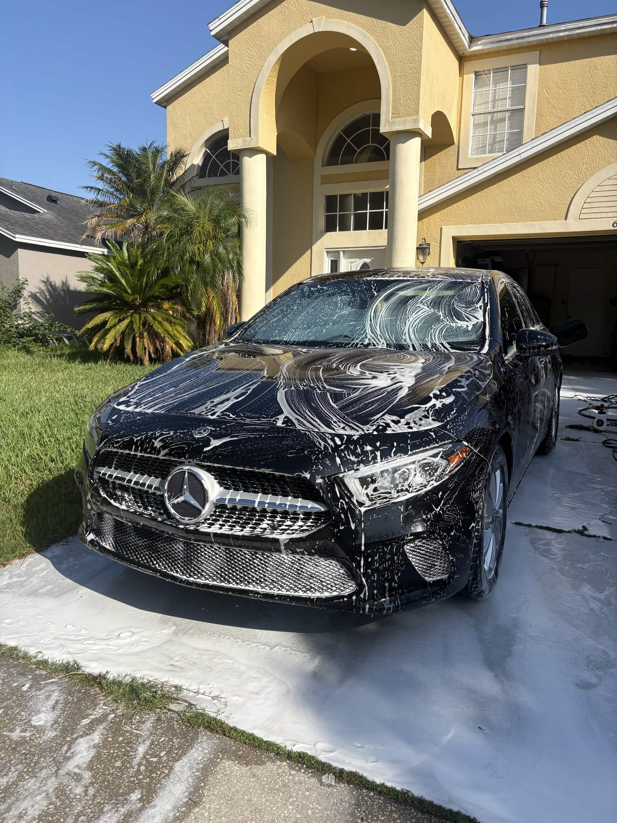 Black Mercedes-Benz covered in snow foam during a mobile hand wash in Melbourne, FL