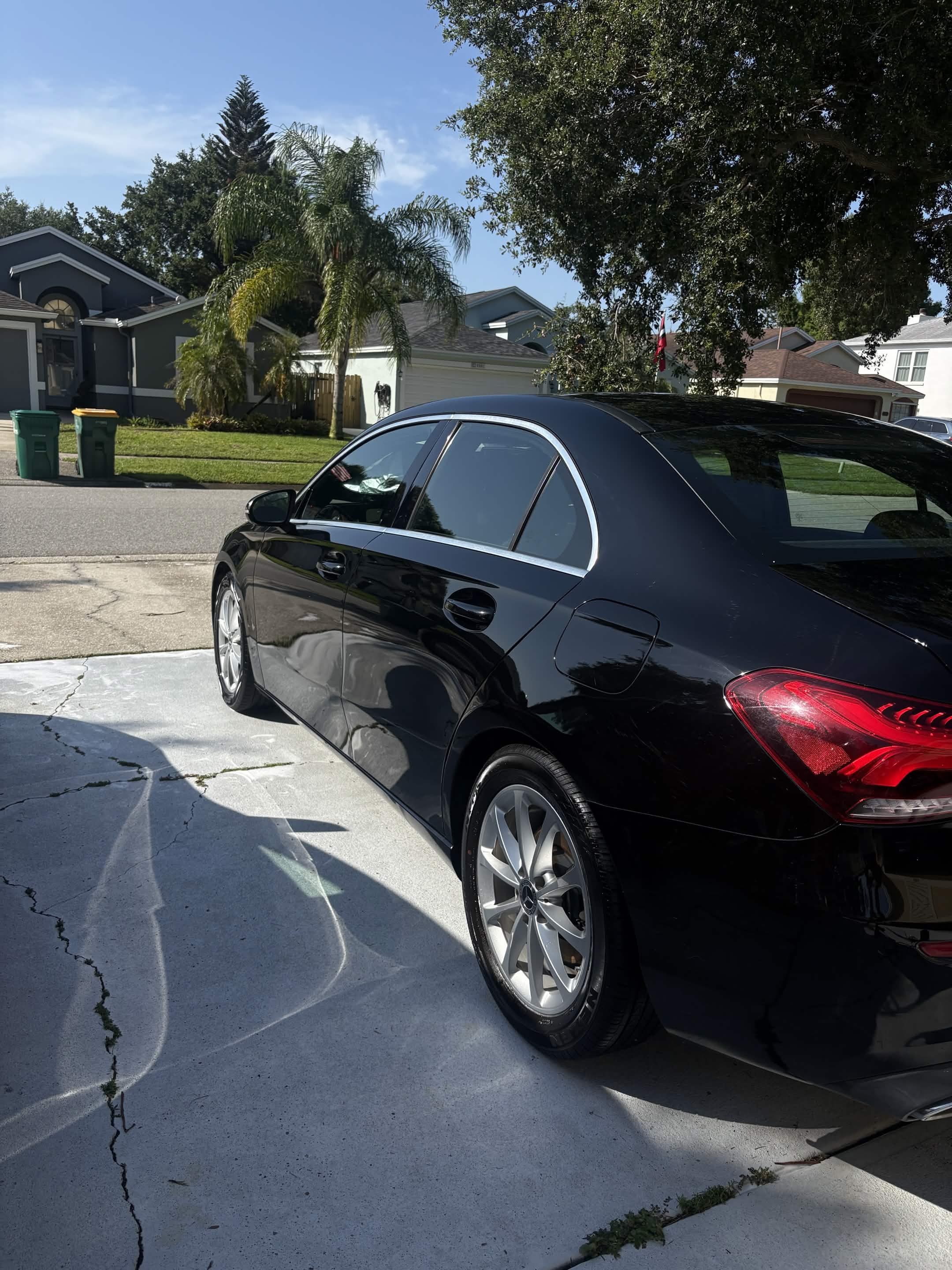 Rear three-quarter view of a glossy black Mercedes-Benz after detailing